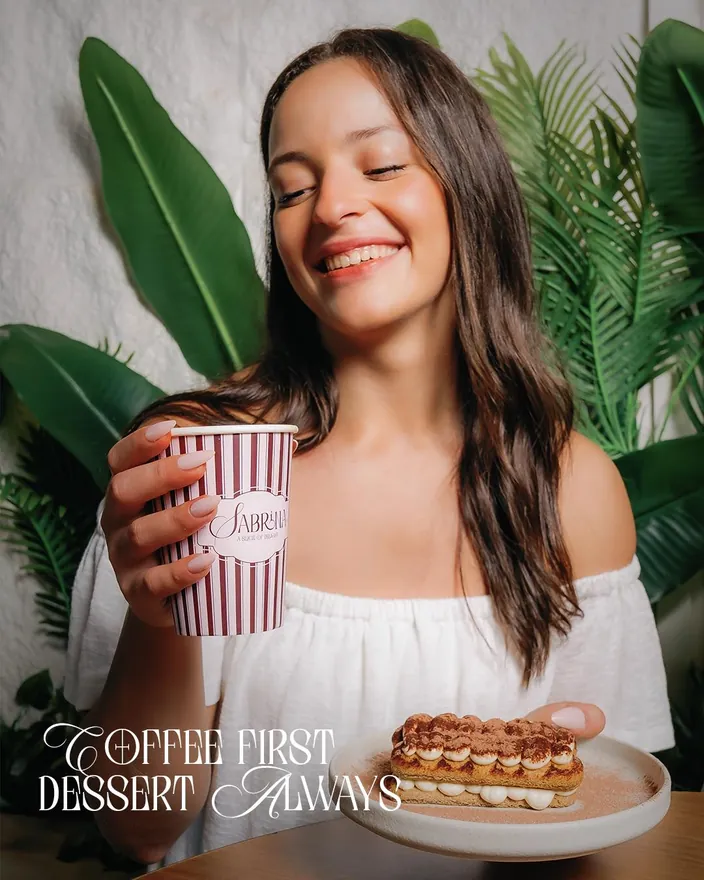 Coffee first, dessert always, a striped Sabrina cup beside an eclair