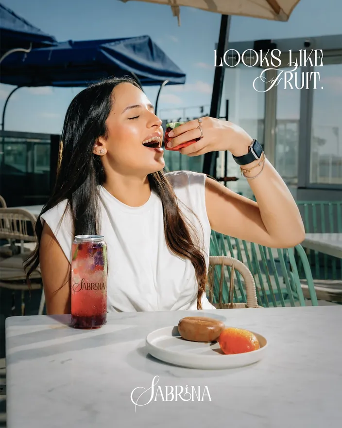 Looks like fruit, a customer at a seaside table with a fruit drink